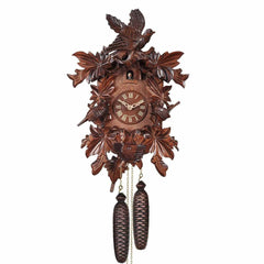 Wooden cuckoo clock with intricate carvings on a white background