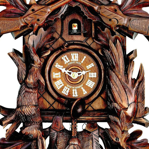  Cuckoo Clock - Carved 1-day Hunting-style cuckoo clock with stag head, two rifles, plesshorn, hanging rabbit and pheasant 42cm by Hubert Herr - Cuckoo Collections